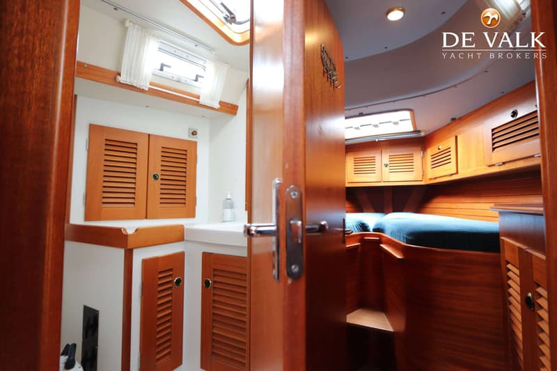 Een interieur van een boot met een badkamer aan de linkerkant en een slaapgedeelte aan de rechterkant. — Hallberg Rassy 39