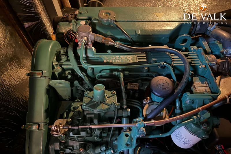 Een close-up van een groene Volvo Penta scheepsmotor met diverse slangen, leidingen en filters.