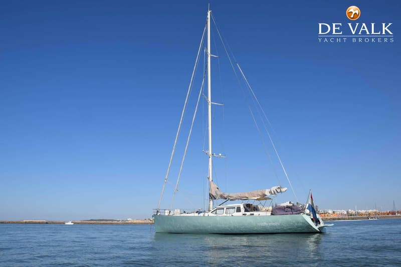 Een lichtgroene zeilboot genaamd "mahi mahi" ligt op het water met een opgerold zeil, mast en Nederlandse vlag. — CRN 63