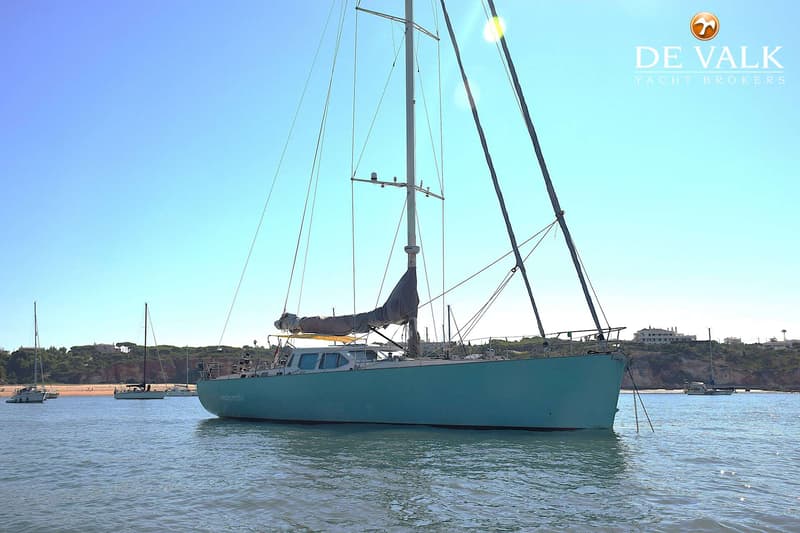 Een lichtblauwe zeilboot met de naam "mahi mahi" ligt op het water, met een opgerold zeil en een mast. — CRN 63