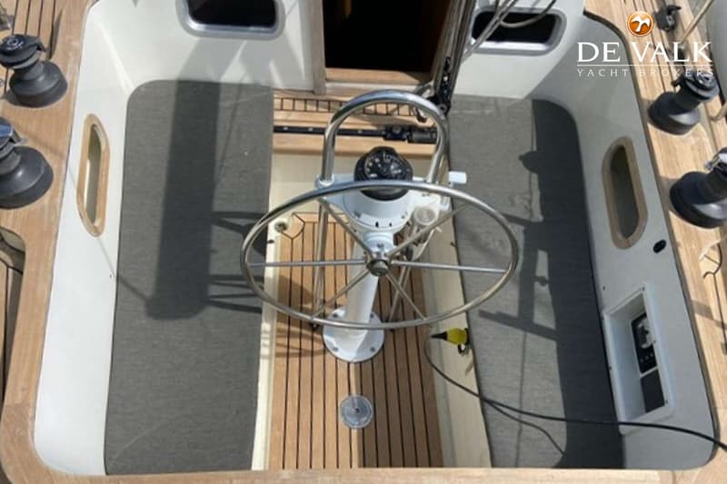 De foto toont het stuurwiel en de kuip van een zeilboot, met een kompas en lieren zichtbaar. — Tradewind 35