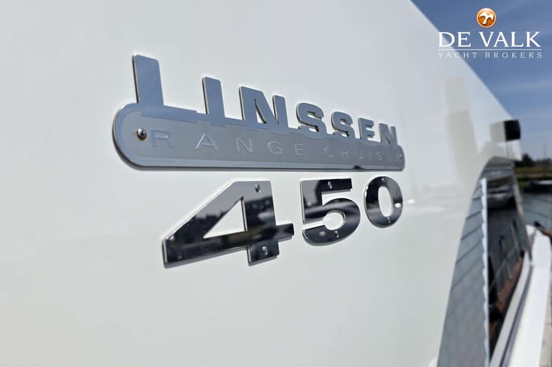 Een close-up van de zijkant van een witte boot met de chrome letters "LINSSEN RANGE CRUISER 450" erop.
