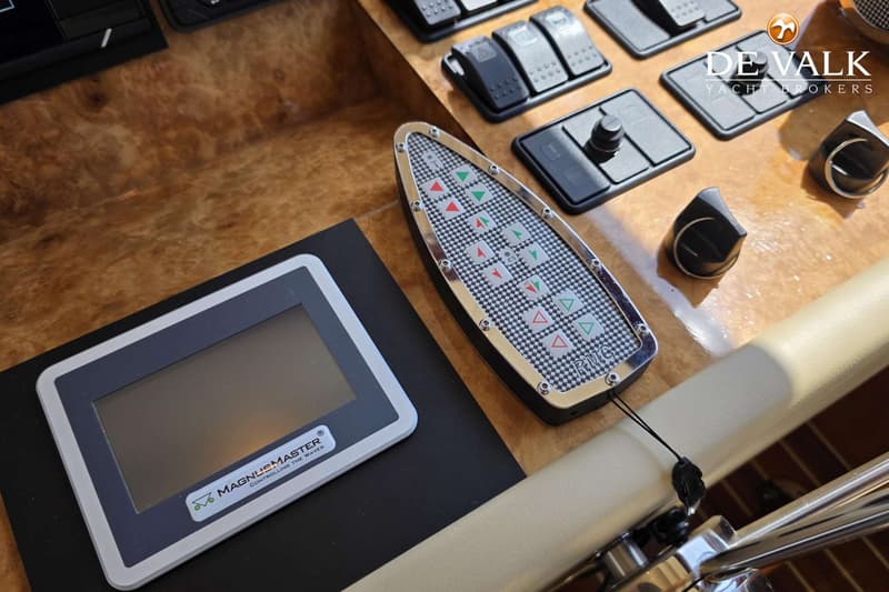 Een detailfoto van een bedieningspaneel met knoppen en een display op een houten oppervlak.