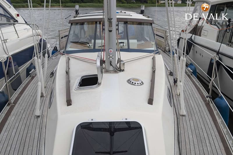 Een bovenaanzicht van het voordek van een zeilboot met een mast, luiken en een houten dek. — LM 35 Vitesse