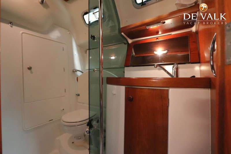 Een interieurfoto van een boot met een toilet, wastafel en houten kasten. — Jeanneau Sun Odyssey 37