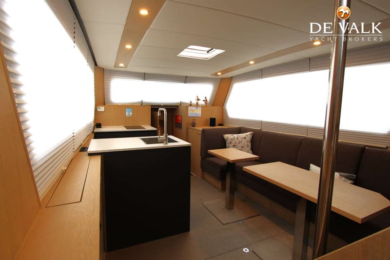 Een interieur van een boot met een kombuis, zithoek, ramen met jaloezieën en een dakluik. — Thomasz Yacht 412 AC