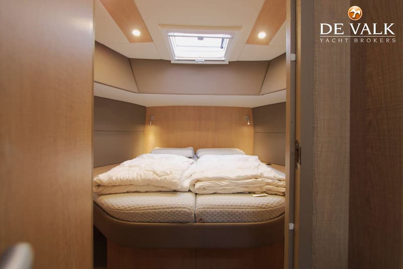 Een kajuit met een tweepersoonsbed, twee kussens, twee dekbedden, twee leeslampjes en een dakraam. — Thomasz Yacht 412 AC