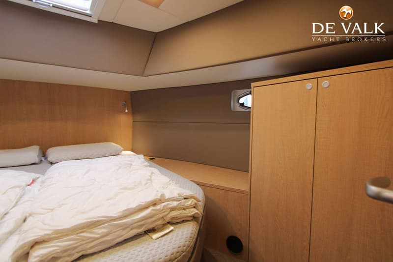 Een kajuit met een bed, een kast, een patrijspoort en een dakraam. — Thomasz Yacht 412 AC
