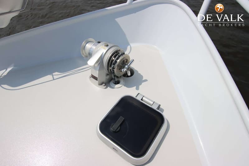 Een ankerlier met ketting en een luik zijn zichtbaar op het witte dek van de boot. — Pedro Skiron 35