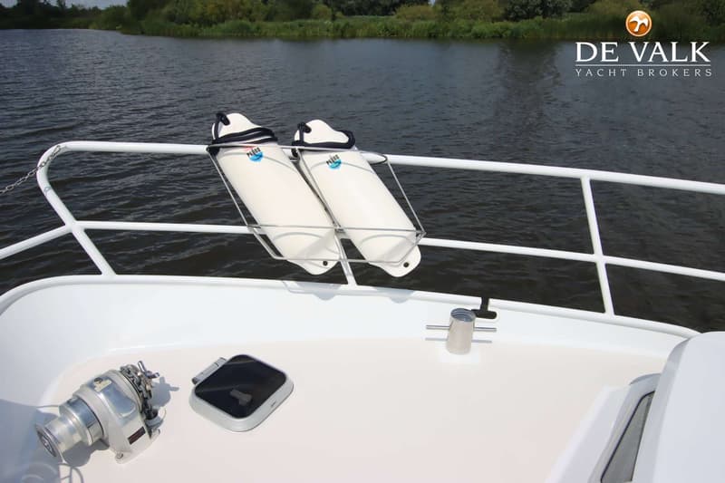 Twee witte stootwillen met "Pedro" logo hangen aan de reling van een boot, met een ankerlier en luik op het dek.