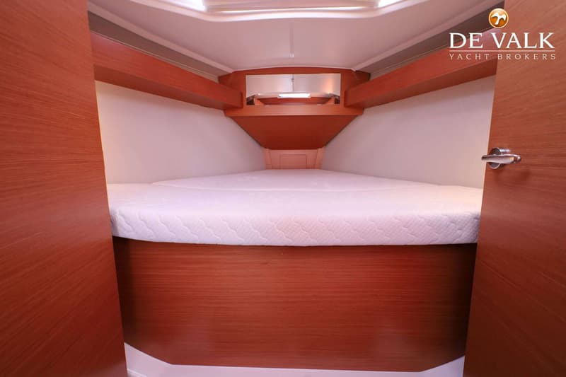 De foto toont een kajuit met een wit matras op een houten bedframe en houten wanden. — Dufour 360 GL
