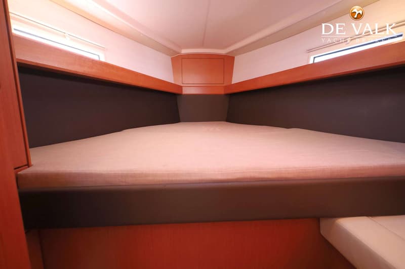 Een kajuit met een tweepersoonsbed, houten afwerking en een raam aan de zijkant. — Bavaria 37 Cruiser
