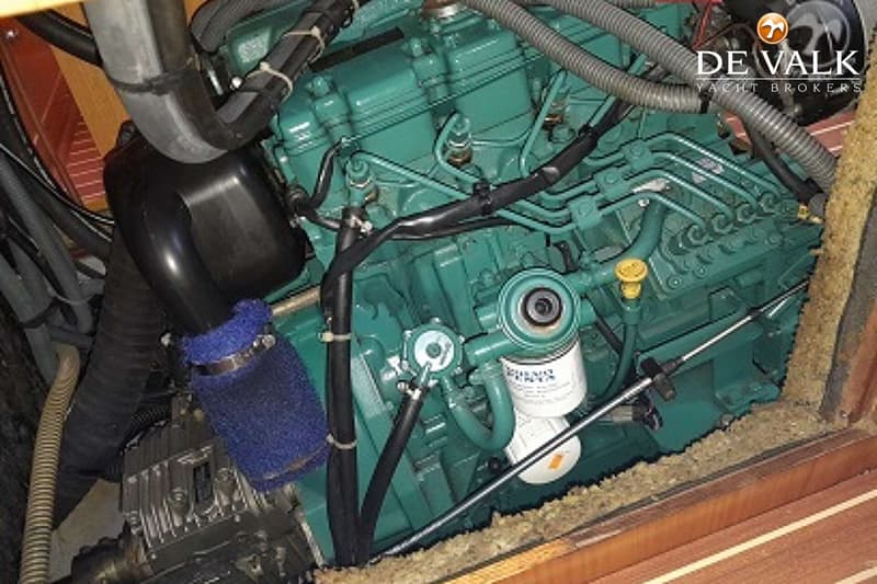 Een close-up van een groene motor met diverse slangen, kabels en een filter met "VOLVO PENTA" erop.