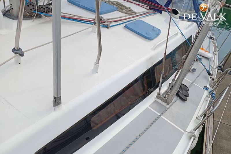 Een bovenaanzicht van het dek van een zeilboot met touwen, kussens en een mast. — Alubat OVNI 445