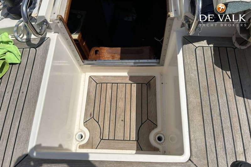 Een bovenaanzicht van de ingang van een boot met een houten vloer en een open luik naar de kajuit. — Maestro 35