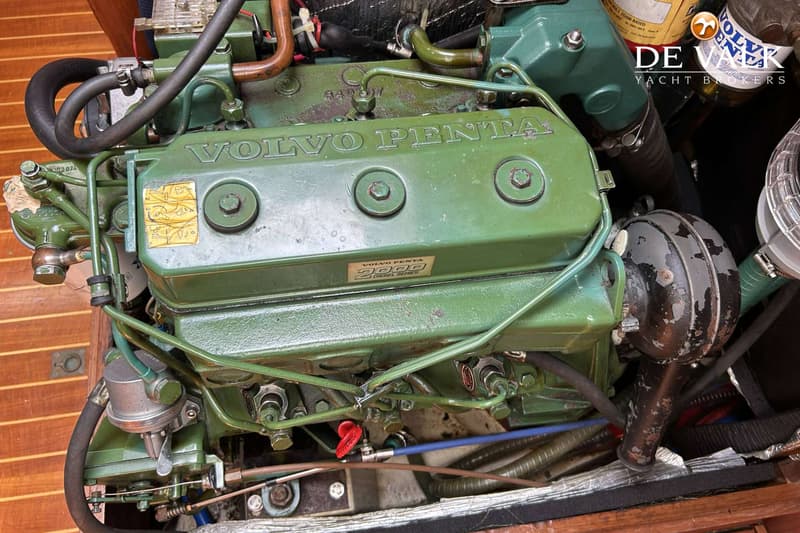 Een groene Volvo Penta 2000 Diesel Series motor met diverse slangen en leidingen is zichtbaar.