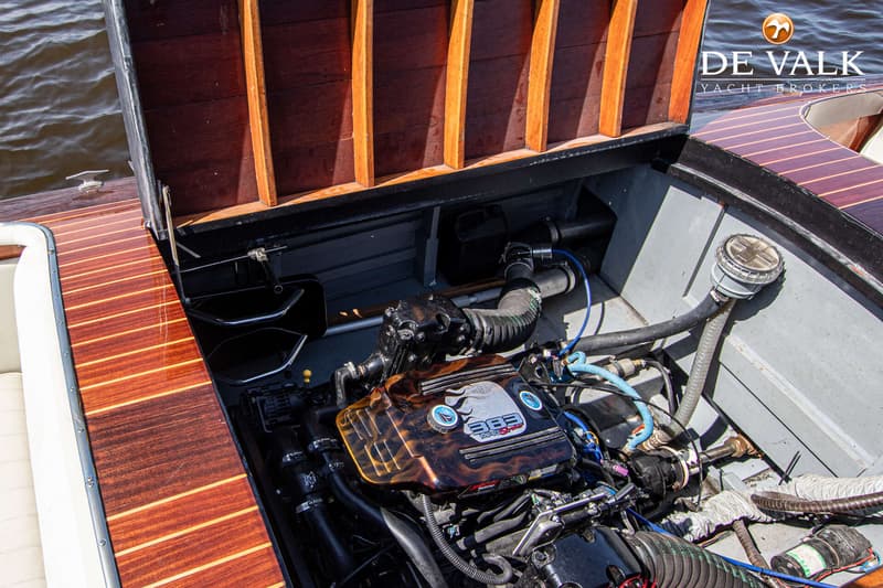 Een open motorruimte met een zwarte motor met een bruin-oranje motorkap met de tekst "383 MAG Stroker".