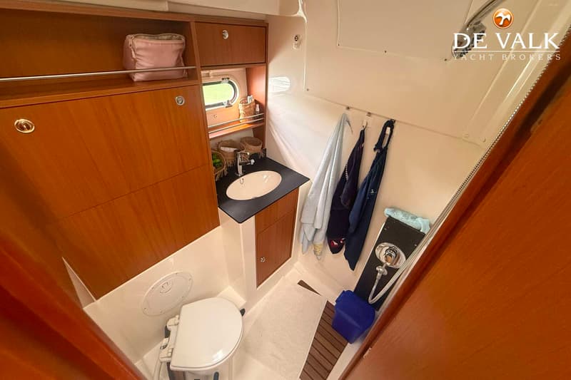 Een badkamer op een boot met een toilet, wastafel, spiegel, douche en handdoeken. — Bavaria Motor Boats 34 Sport