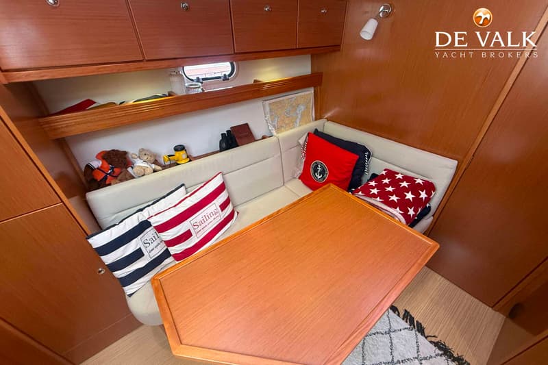 Een interieur van een boot met houten wanden, een bank met kussens en een houten tafel. — Bavaria Motor Boats 34 Sport