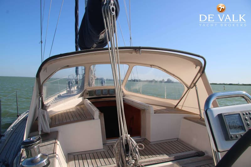 Een zeilboot met een beige buiskap en een teakdek, gezien vanaf de kuip richting de boeg. — Victoire 42 Classic