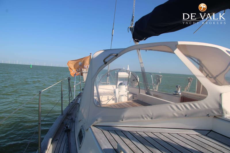 Een zeilboot met een beige buiskap en teakdek vaart op open water met windmolens aan de horizon. — Victoire 42 Classic
