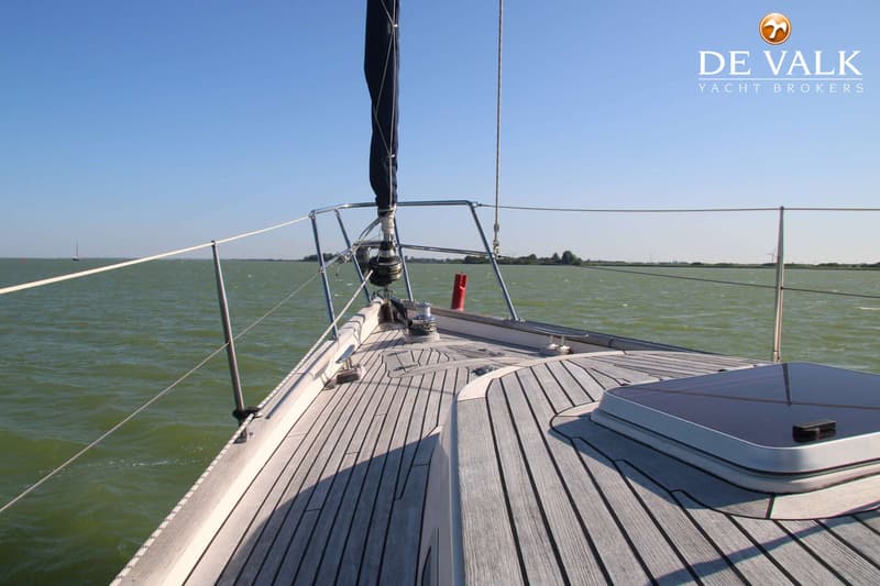 Een zeilboot met een houten dek vaart op een waterlichaam onder een heldere blauwe lucht. — Victoire 42 Classic