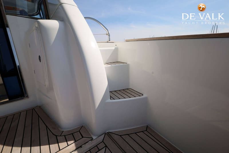 Een witte boot met een trap met houten treden en een houten vloer, onder een blauwe lucht. — Beneteau Flyer 12 Cabin