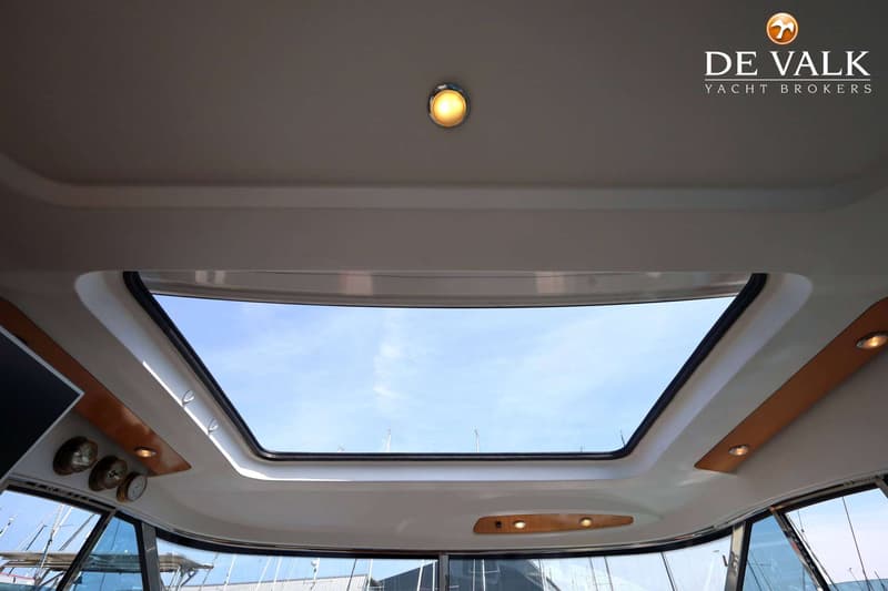 Een interieurfoto van een boot met een groot dakraam dat uitzicht biedt op een blauwe lucht. — Beneteau Flyer 12 Cabin