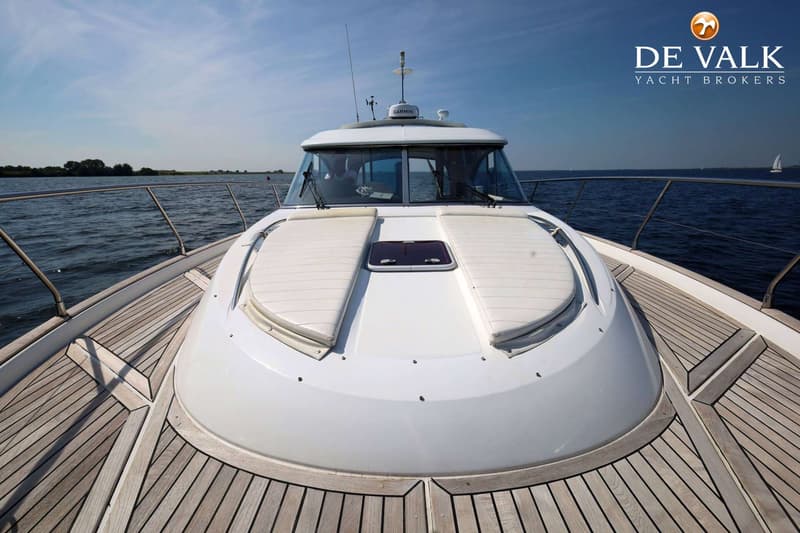 Een witte boot met een houten dek en twee witte kussens op het voordek, varend op open water. — Beneteau Flyer 12 Cabin