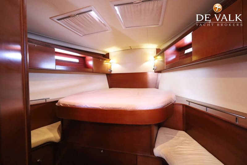 Een kajuit met een tweepersoonsbed, twee eenpersoonsbedden, kasten, leeslampjes en dakluiken. — Dufour 485 Grand Large