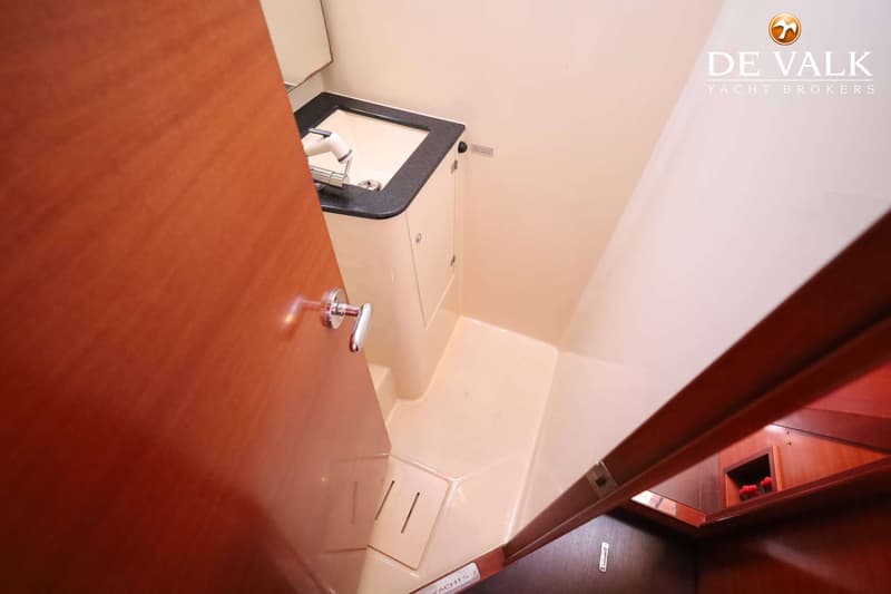 Een interieurfoto van een badkamer of natte cel met een wastafel, een kraan en een houten deur.