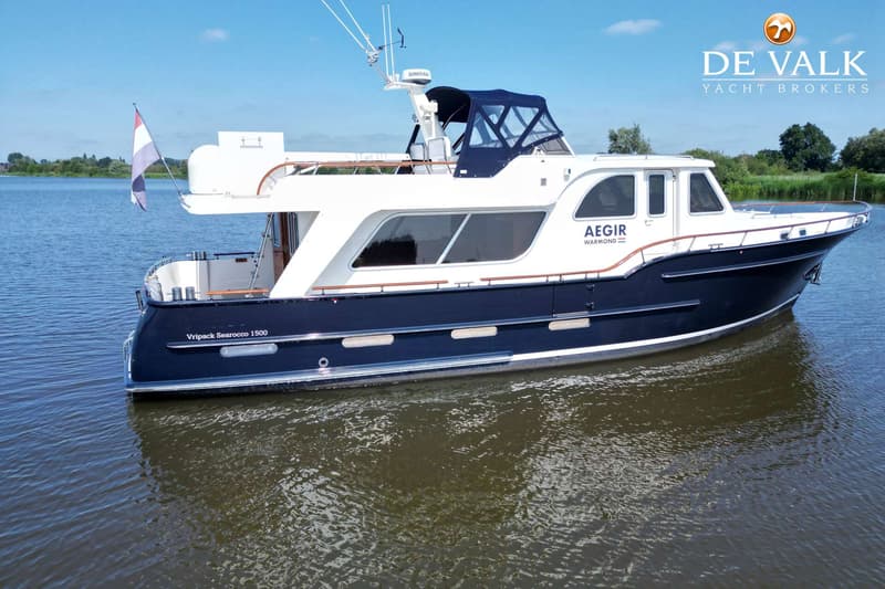 Een blauw-witte motorboot met de naam "AEGIR WARMOND" en "Vripack Searocco 1500" ligt in het water. — Vripack Searocco 1500