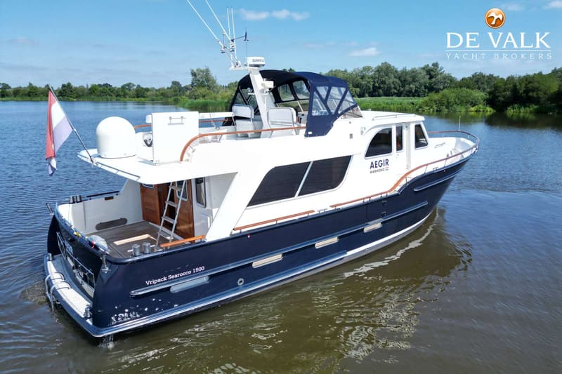 Een blauw-witte boot met de naam "AEGIR" en "Vripack Searocco 1500" vaart op een waterweg. — Vripack Searocco 1500