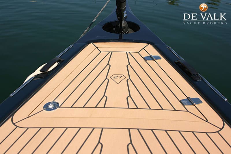 Een bovenaanzicht van de boeg van een boot met een houten dek en het nummer 27 in een ruitvorm. — Saffier SE27 Leisure