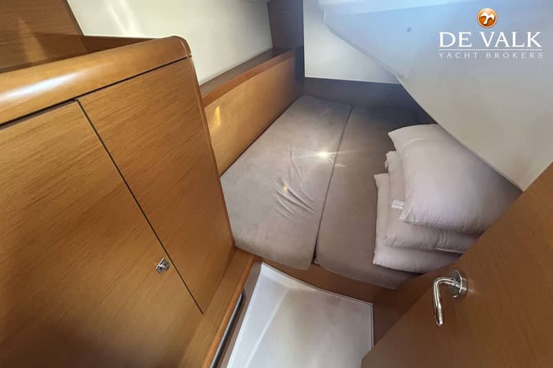 Een kajuit met een bed, houten kasten en een wit plafond. — Jeanneau Sun Odyssey 349