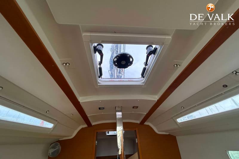 De foto toont het interieur van een boot met een open dakluik en een houten afwerking. — Jeanneau Sun Odyssey 349