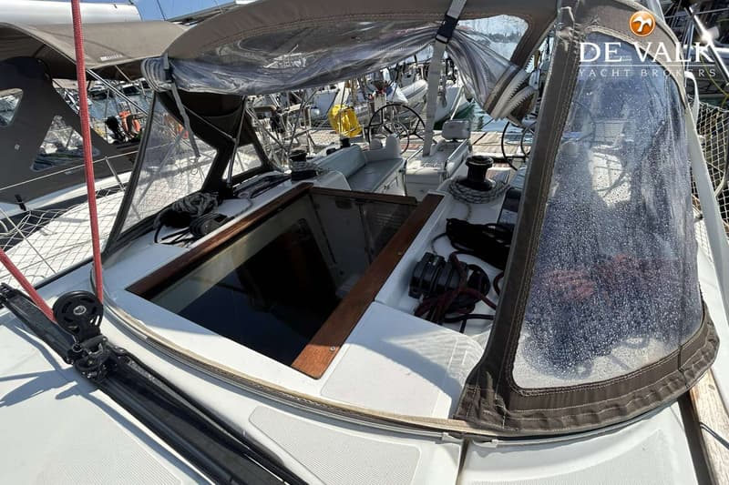Een bovenaanzicht van de kuip van een zeilboot met een open kajuitingang en een buiskap. — Jeanneau Sun Odyssey 419