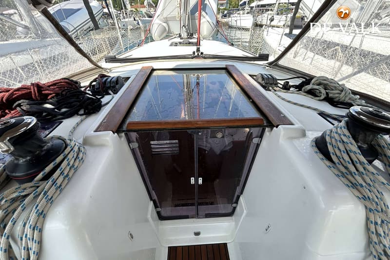 Een bovenaanzicht van de kajuitingang van een zeilboot met een transparant luik en twee donkere deuren.