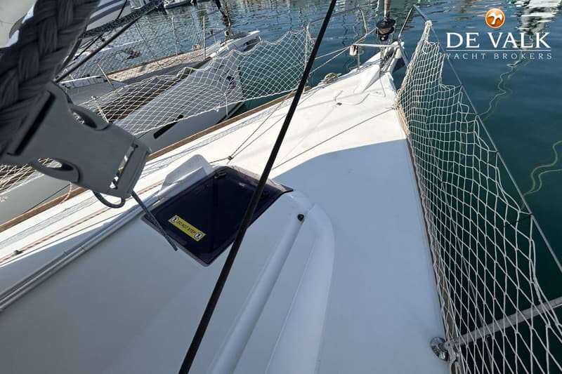 Een bovenaanzicht van het dek van een witte zeilboot met een luik, touwen en een vangnet. — Jeanneau Sun Odyssey 419
