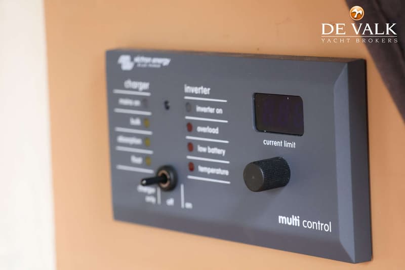 Een detailfoto van een grijs bedieningspaneel met de tekst "multi control", "charger" en "inverter".