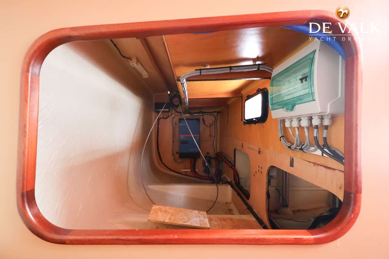 Een interieurfoto van een boot met een houten afwerking, een elektrisch paneel en diverse kabels. — Custom Aluminium Cruiser
