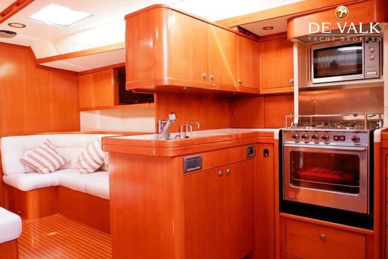 Een houten interieur met een kombuis, zithoek en een fornuis met oven.