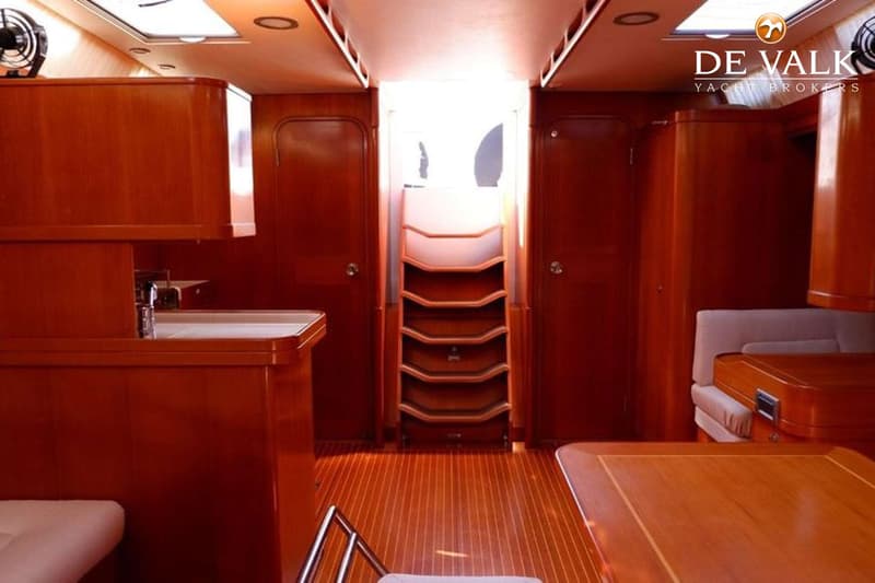 De foto toont het interieur van een boot met een houten vloer, houten kasten en een trap in het midden. — Baltic 60