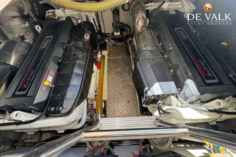 Twee zwarte Volvo Penta D9-575 scheepsmotoren zijn zichtbaar in een motorruimte, met een metalen rooster op de vloer.