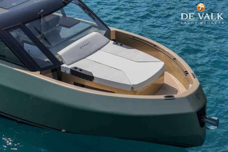 Een bovenaanzicht van de boeg van een boot met een zonnedek en een voorruit, varend op blauw water. — Forte 47 GT
