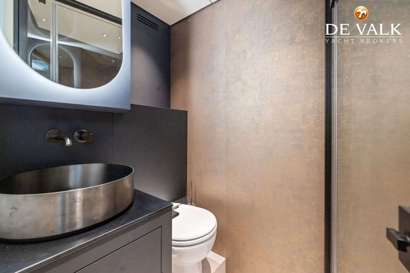 Een badkamer met een spiegel, wastafel, kraan, toilet en een douchecabine.