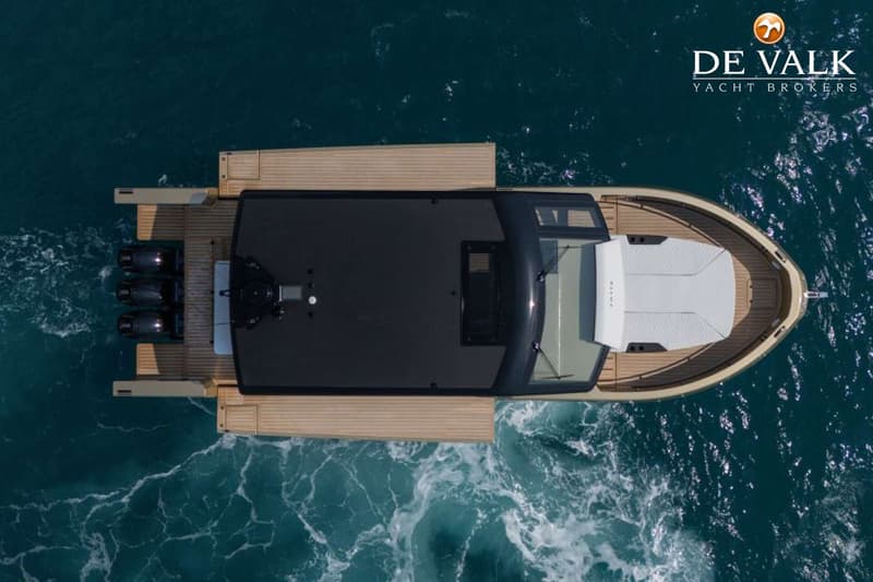 Een dronefoto van bovenaf toont een motorboot met vier buitenboordmotoren, varend op turquoise water. — Forte 47 GT