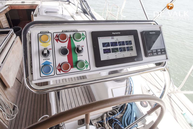Een close-up van een stuurstand met bedieningspanelen voor anker en jet-thruster, en twee Raymarine displays.