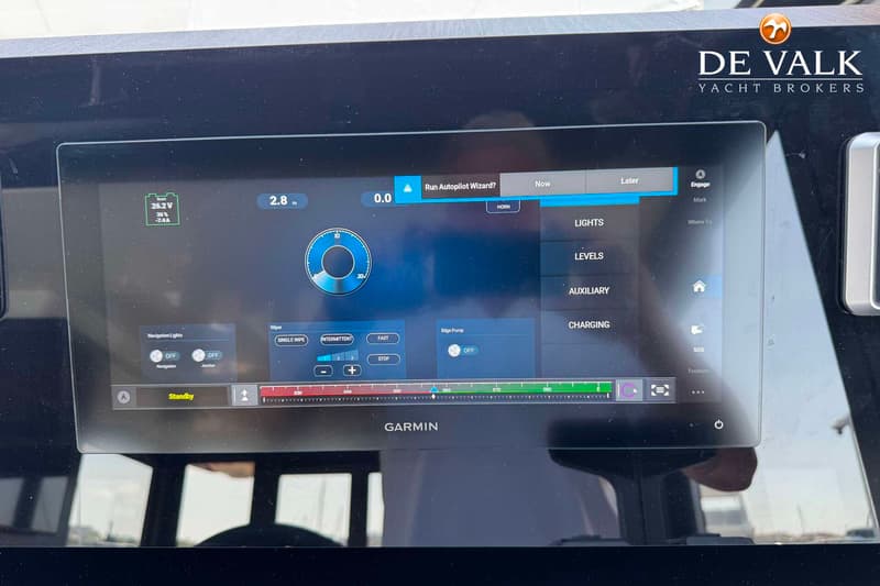 Een Garmin multifunctioneel display toont navigatie-informatie, batterijstatus en bedieningselementen voor verlichting en…