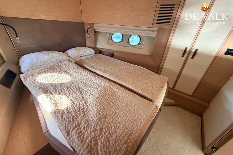 De foto toont een kajuit met twee eenpersoonsbedden, twee patrijspoorten en een kledingkast. — Beneteau Monte Carlo 5